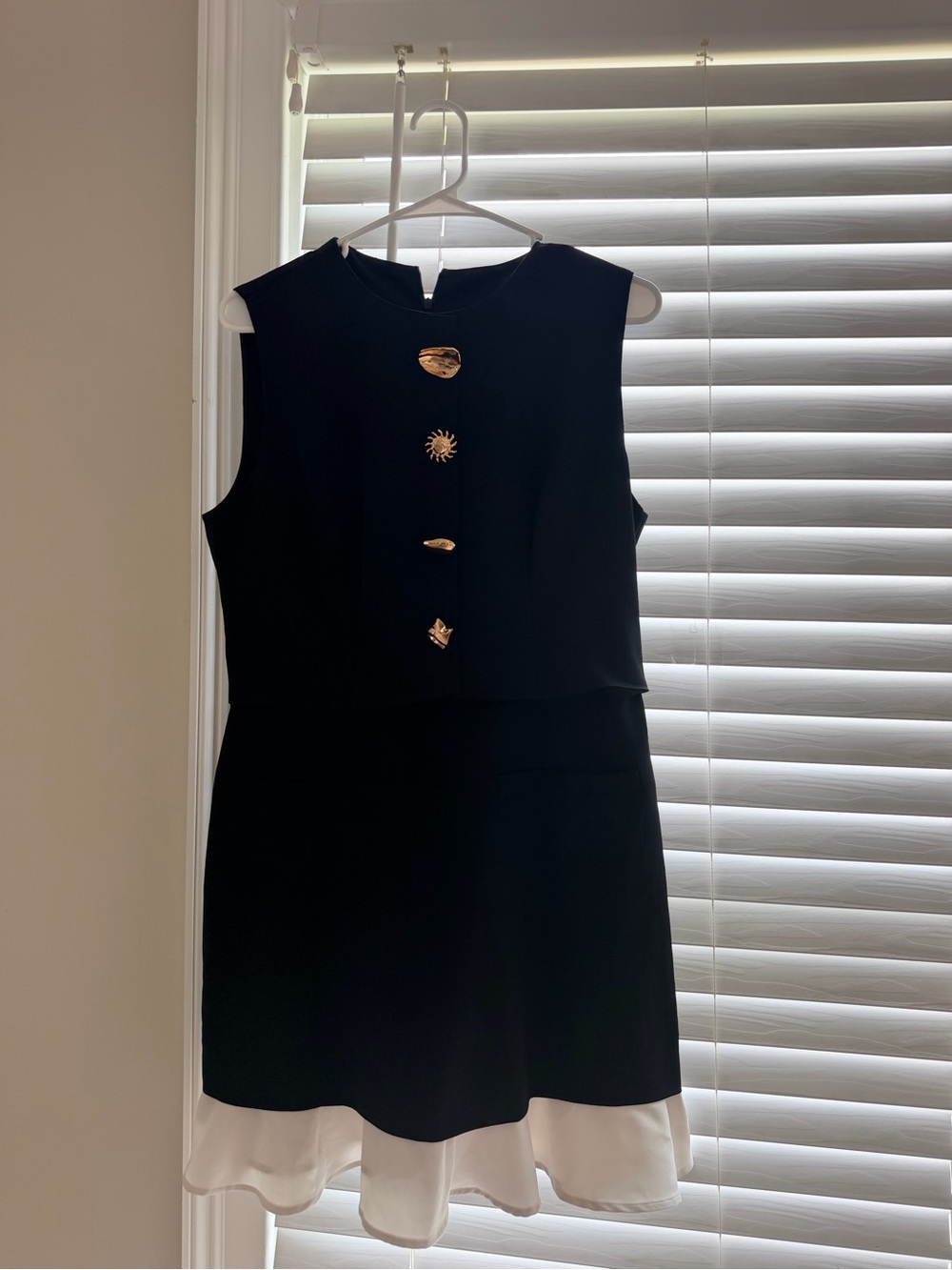 Sleeveless Black Mini Dress with Gold Decorative Buttons and White Hem